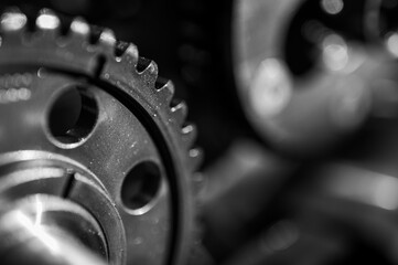 Black and white close-up of metal gears and mechanical parts symbolizing industrial equipment,...