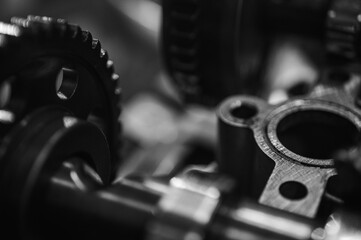 Black and white close-up of metal gears and mechanical parts symbolizing industrial equipment,...