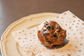 Oliebol fresh Dutch pastry on plate festive tissue. New years treat in the Netherlands. Happy New Year snack.