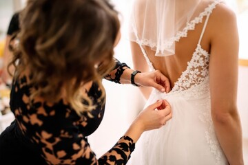 Woman helping bride put on a garter