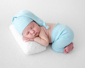 Newborn Baby Sleeps On Pillow During Photo Session