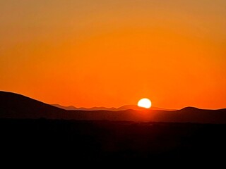 Fototapeta premium Golden Sunrise Over Desert Horizon