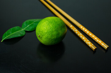 Kaffir lime leaf and lime, Asian ingredients on a black background