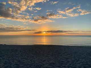 Gulf Coast ocean at sunset with clouds and orange blue sky