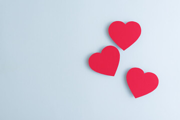 Red paper hearts of various size lying on pastel blue background. Valentines Day, love and feelings concept, top view