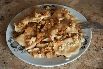 Traditional Ukrainian dish, potato dumplings with cracklings. Selective focus