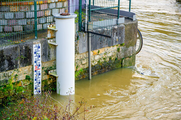 A water level gauge with  controlling station. Gauge rod in water on Marne river in Paris on Joinville Dam