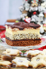 Multi layer cake with vanilla, poppy seed and chocolate among Christmas decorations.