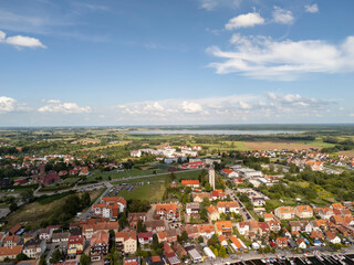 Aerial view of Mikolajki in Masuria showcasing charming houses and lush green surroundings with blue skies