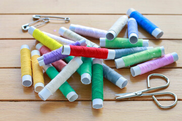 Colorful threads on wooden table.