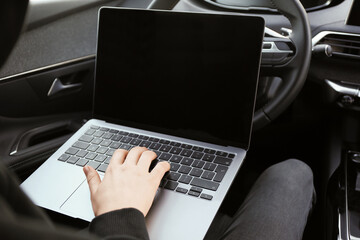 Thief hacking car system with laptop inside vehicle, closeup