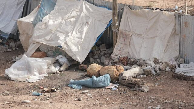 A homeless man sleeps under a makeshift shelter on the streets in Africa.