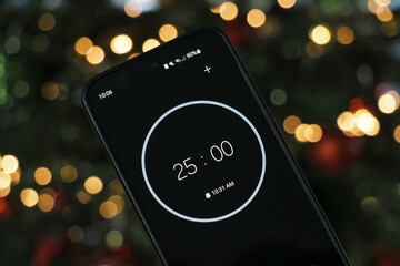 A phone with a black and white 25-minute timer to study with the pomodoro method on a blurry...