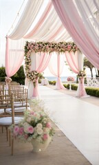 Romantic wedding setup with pink drapes and floral arrangements by the waterfront