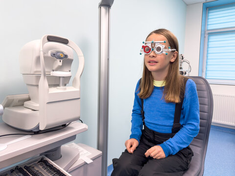 Examination child with eyeglasses. Optometrist performing visual test of child.  Ophthalmology test of eyes for kids.