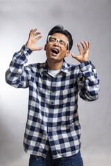 Fototapeta premium portrait of a young black Southeast Asian man in a plaid suit with a disappointed expression and open mouth, isolated white background angry