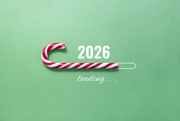 Striped candy cane and lettering 2026 loading on green background. Concept of waiting for seasonal...