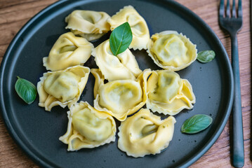 Tortellini with mozzarella and spinach in a black dish