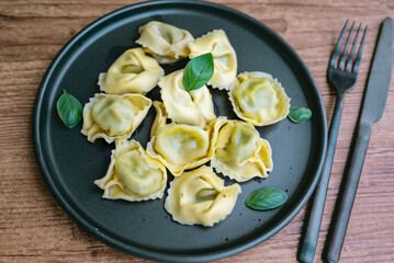 Tortellini with mozzarella and spinach in a black dish