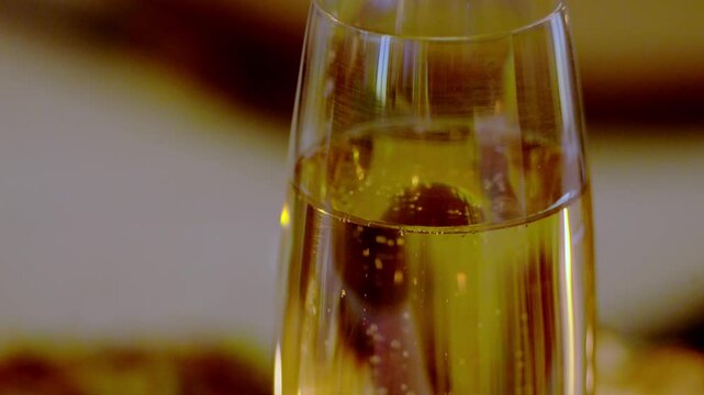 plan fixe sur une coupe de champagne, une soir&eacute;e de f&ecirc;te avec des amis, zoom transversale sur la coupe de champagne pour laisser apparaitre les flamme de bougies,