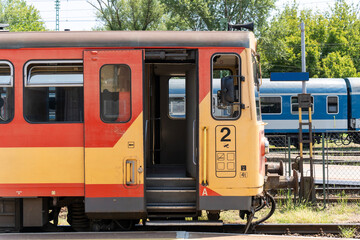 Old red yellow train car at a Hungarian railway station in summer
