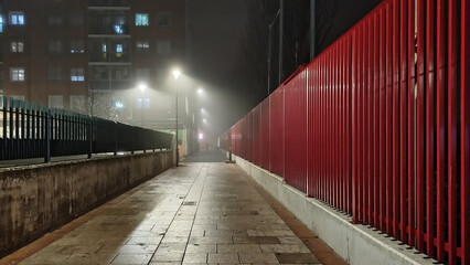 Calles con valla roja en la noche con niebla tenebrosa y solitaria de Burgos, España
