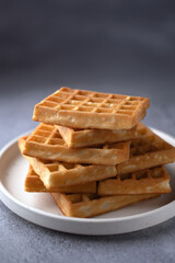 photo Crisp and Golden Waffle Stack on a Plate: Perfectly Cooked Breakfast Delight Ready to Serve for a Delicious Start to Your Day or a Sweet Treat at Any Time