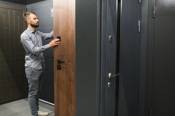 A young man chooses metal front door in the hardware store