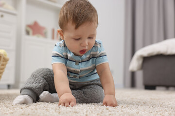 Adorable baby boy on floor at home