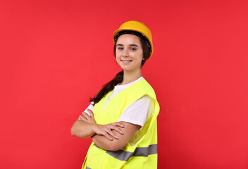 Girl with safety equipment on red background. Work for teenagers