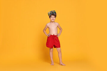 Little boy in beachwear with diving mask on orange background © New Africa