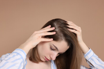 Fototapeta premium Girl with hair loss problem on dark beige background