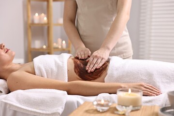 Woman undergoing chocolate body wrap treatment in spa salon, closeup