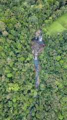Vertical top view shot of a landscape surrounded by nature with the Nauyacas Waterfalls of the Baru River in the middle of the green tropical forest in Costa Rica