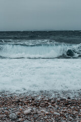 Rocky Shoreline with Choppy Waves Under an Overcast Sky