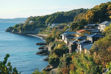 Naklejka premium Coastal houses nestled on a hillside, ocean view.