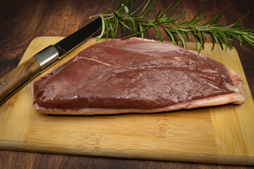 magret de canard cru, en gros plan, sur une planche à découper