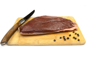 magret de canard cru, en gros plan, sur une planche à découper