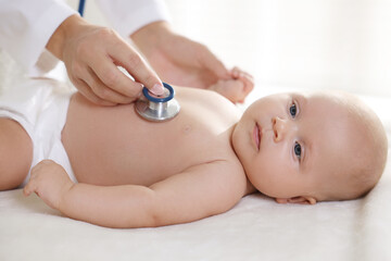 Pediatrician examining little child with stethoscope in clinic, closeup. Checking baby's health