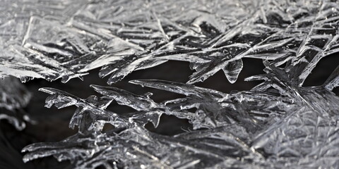 Interesting shaped icicles in frozen river. Beauty of winter weather. Czech republic nature in winter. River covered by ice.
