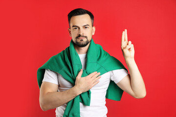 Fototapeta premium Man showing oath gesture on red background. Making promise