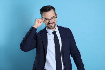 Portrait of smiling banker on light blue background