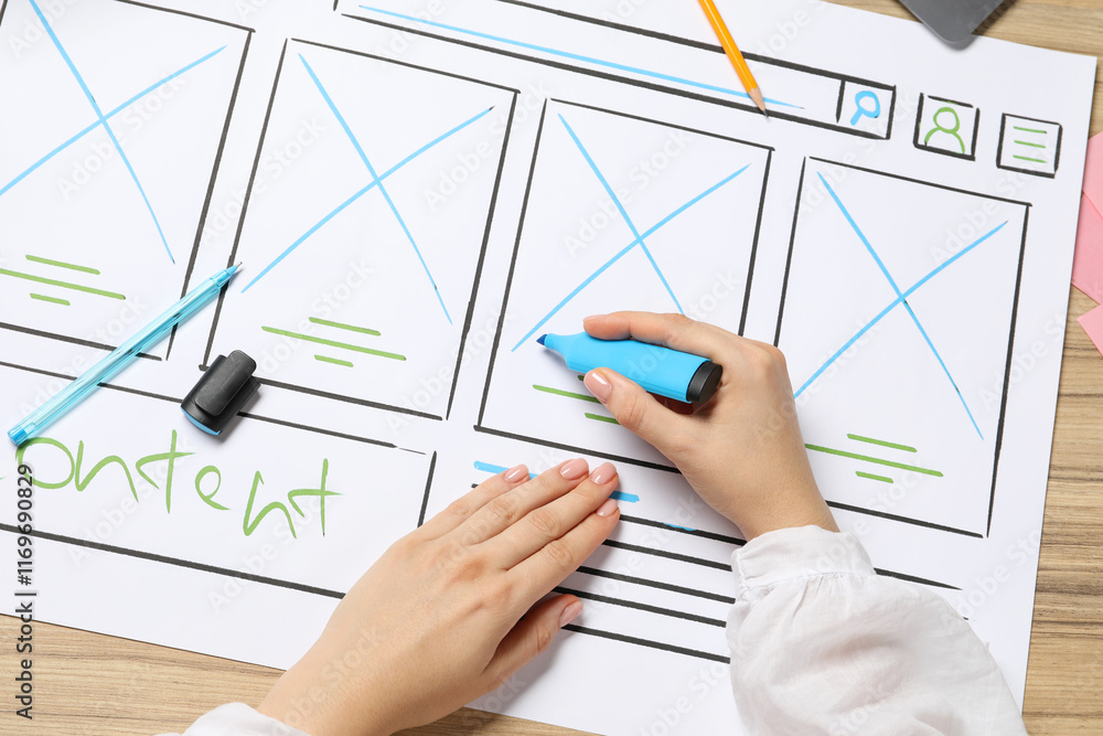Poster website designer creating wireframe on paper with highlighter at wooden table, top view