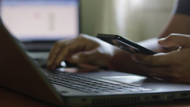 Cyber security 2FA protection concept. Businessman working on a laptop to login password two-step authentication, verification code on smartphone screen for identity identification for online banking.