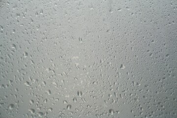 Misted glass background and Detail of water droplets, gloomy gray day. Window and rain outside | Foreground overlay for beauty and skin care products