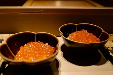 Two small glazed ceramic bowls of ikura don (salmon roe rice bowl) served as part of an omakase lunch at Manten Sushi Marunouchi near Tokyo Station and the Imperial Palace - Chiyoda City, Tokyo