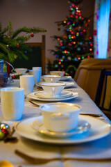 Festive Christmas Eve dinner table set with elegant decorations and colorful tree