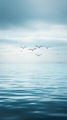Fototapeta premium Tranquil Seascape with Birds Flying Over Calm Water Surface