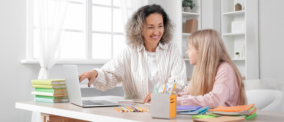 Little girl studying Math with tutor at home