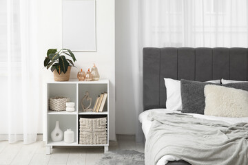 Interior of light bedroom with shelf unit and decorative pumpkins